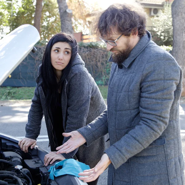 Couple triste debout dans la rue avec moteur de voiture cassé — Photo