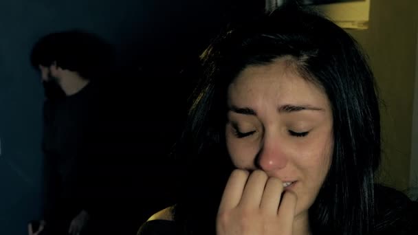 Женщина плачет, пока ее парень напивается в темноте — стоковое видео