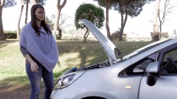 Відчайдушні жінки дивляться зламаний двигун автомобіля на вулиці з проханням про допомогу — стокове відео