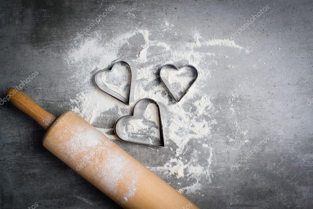 Flour, cookie cutters shaped as heart and rolling pin on a stone Stock  Photo by ©karidesign 107741166