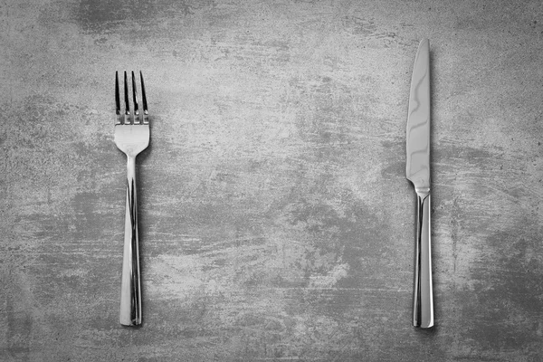 Widelec i nóż na tle konkretnych — Zdjęcie stockowe