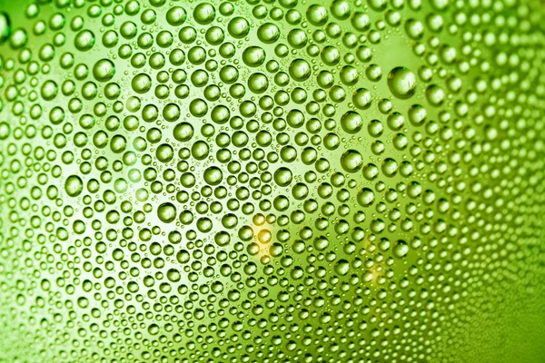 Gotas de agua verde amarilla en una botella — Foto de Stock