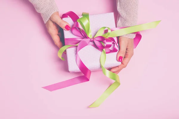 Coffret cadeau rose avec arc dans les mains des femmes. Images De Stock Libres De Droits