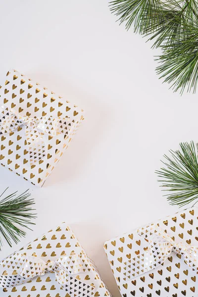 Coffrets cadeaux en papier blanc avec des cœurs dorés sur fond blanc. Photo De Stock