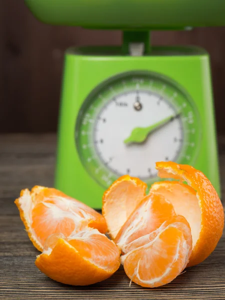 Fresh tangerine on the scales green — Stock Photo, Image