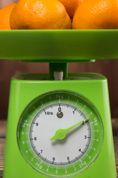 Fresh tangerine on the scales green — Stock Photo, Image
