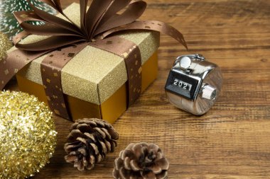 İçinde altın Noel mücevherleri, çam kozalakları ve hediye kutusu olan 2021 numaralı el bilgisayarı. 2021 Yeni Yıl Kutlama Konsepti.