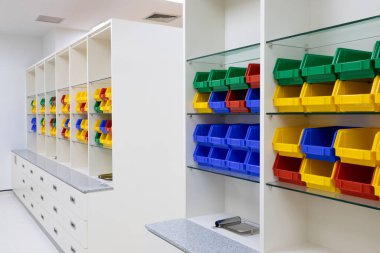 Depolama için çok renkli kutuları olan modern eczane rafları.