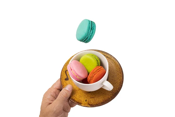 Colorful Macaroons Levitating White Tea Cup Hand Holding Yellowish Brown — Stock Photo, Image