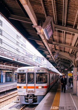 30 Mayıs 2013 Nagoya, Japonya - Gifu yerel tren hattı durağı Nagoya istasyonundaki JR Chuo ana hattında Japon yolcular sarı çizginin gerisinde yürüyor.