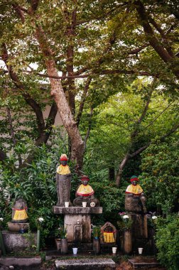 Japonya, Nagoya 'daki Nittai-Ji' de önlüklü ve şapkalı Jizo Bosatsu taş keşiş heykelleri. Jizo, erken ölen kürtaj olmuş çocukların velisi..