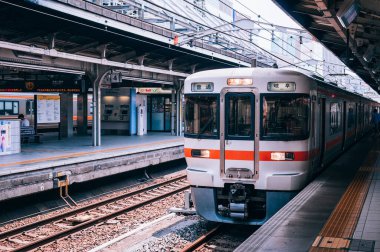 30 Mayıs 2013 Nagoya, Japonya - Japon yolcular sarı çizginin gerisinde yürürken Nagoya istasyonundaki JR Chuo Main platformunda Gifu tren durağı