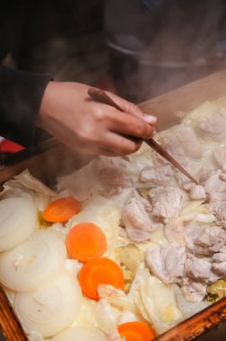 Noboribetsu Tarihi Jidaimura, Hokkaido, Japonya 'da ahşap kutudan tavuk buharı toplayarak çekilen eller..
