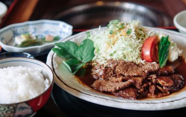 Top view shot of grilled Ishigaki beef premium wagyu A5 with salad, rice and sea grape seaweed at local restaurant, Okinawa, Japan