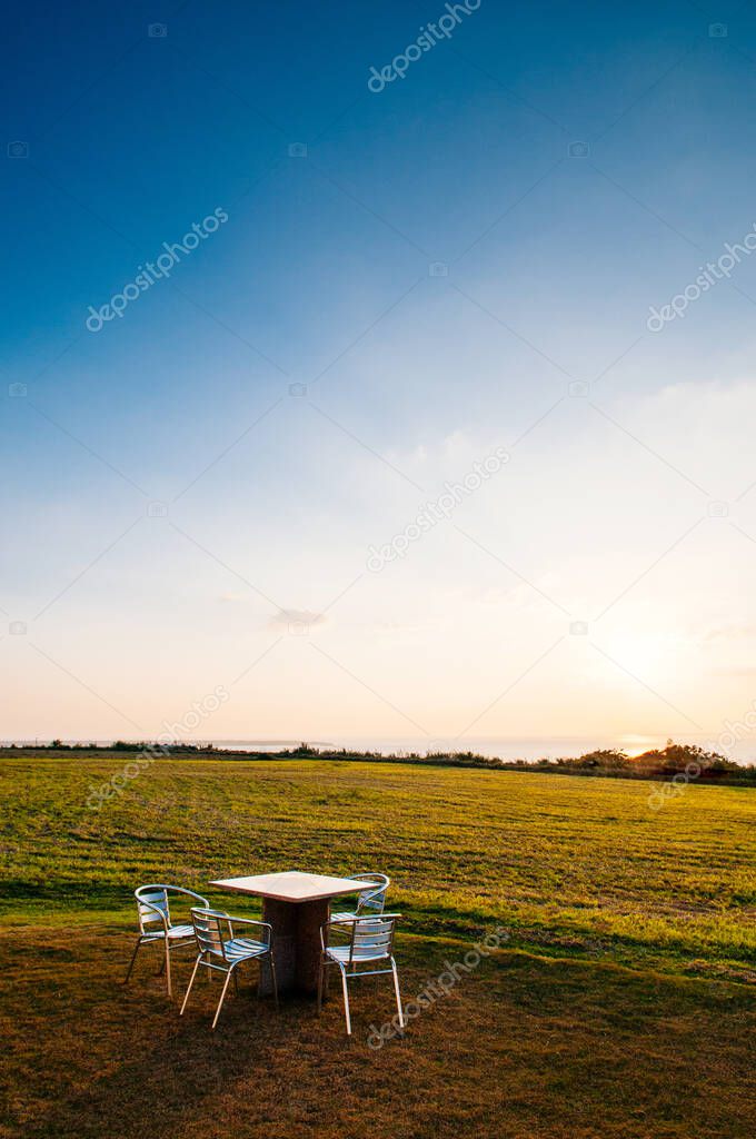 Wide Grass field by the ocean with picnic table at sunset or sunrise in Ishigaki island, Okinawa, Japan