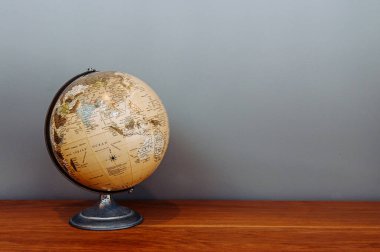 Dünya 'nın klasik okul modeliydi. Küre ikonu. Dünya üzerindeki kıtaların ve okyanusların küresel haritası. Doğal ahşap zemin zeminindeki gri zemin modeli.