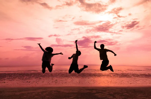 年轻人喜欢日落时在海滩上跳跃 — 图库照片
