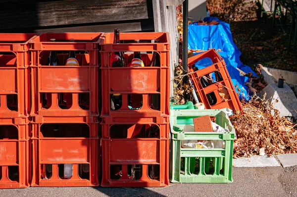 Red beer crate box with empty bottle under bright sunlight high contrast. After party at bar concept.