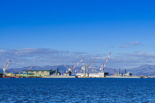 DEC 2, 2018 Hakodate, JAPAN -Hakodate blue harbour bay and industrial port with large cranes and ship mountain view background