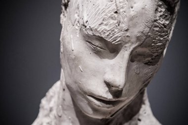 Koyu gri arkaplanda kadın alçı heykeli