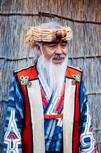 NOV 20, 2013 Hokkaido, JAPAN - Shiraoi Ainu Müzesi 'nde Ainu geleneksel kabile kostümü giyen bir adam. Kuzey Japonya 'nın yerli halkı..