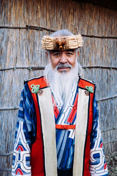 NOV 20, 2013 Hokkaido, JAPAN - Shiraoi Ainu Müzesi 'nde Ainu geleneksel kabile kostümü giyen bir adam. Kuzey Japonya 'nın yerli halkı..