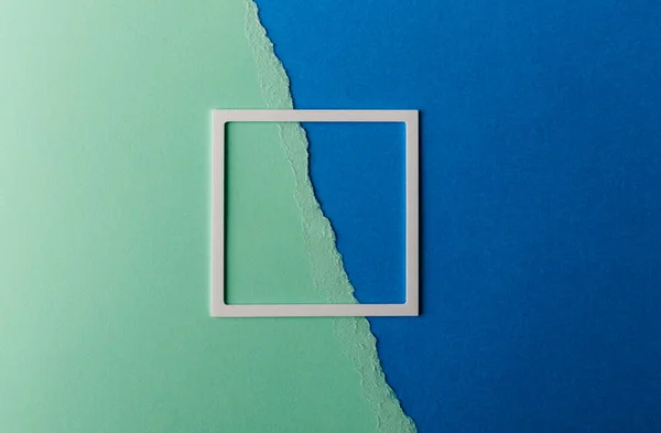 Weißer Kunststoffrahmen Mit Kopierraum Auf Grünem Und Blauem Papierhintergrund Zerrissenes — Stockfoto