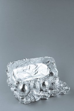 Mavi arkaplanda alüminyum folyo ve kopyalama alanı olan yumurtalar. Uzay yolculuğu ve gıda konsepti.