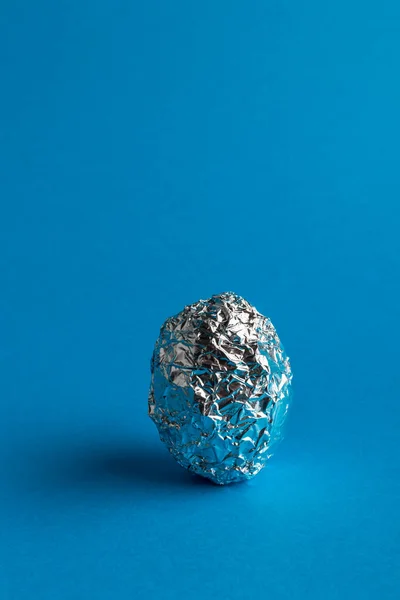 Uovo Foglio Alluminio Sfondo Blu Con Spazio Copia Simbolo Pasquale Immagine Stock
