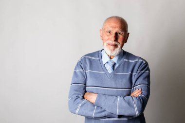 Gri arka planda fotokopi çeken yaşlı bir adam. Sakallı yaşlı bir adamın portresi. Kıdemli adam.