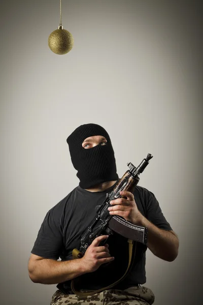 Homem em máscara com arma e brinquedo de Natal — Fotografia de Stock