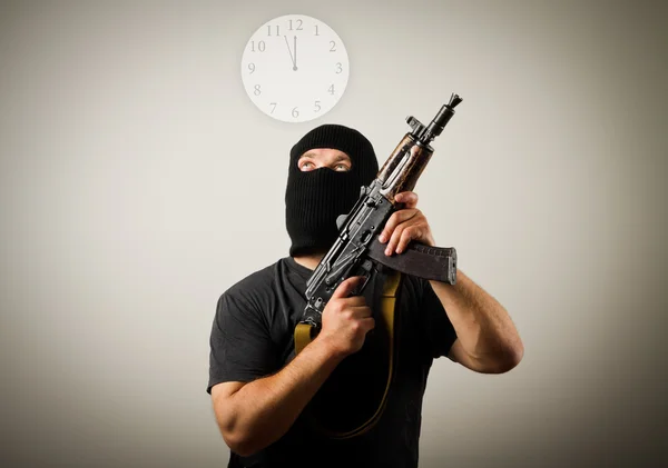 Man with gun and clock. — Stock Photo, Image