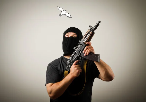 Man with gun and peace dove. — Stock Photo, Image