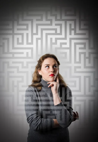 Maze. Jenta i grått løser et problem . – stockfoto