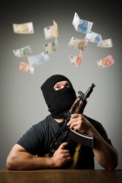 Man with gun and euro banknotes. — Stock Photo, Image