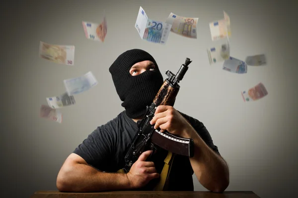 Man med pistol och eurosedlar. — Stockfoto