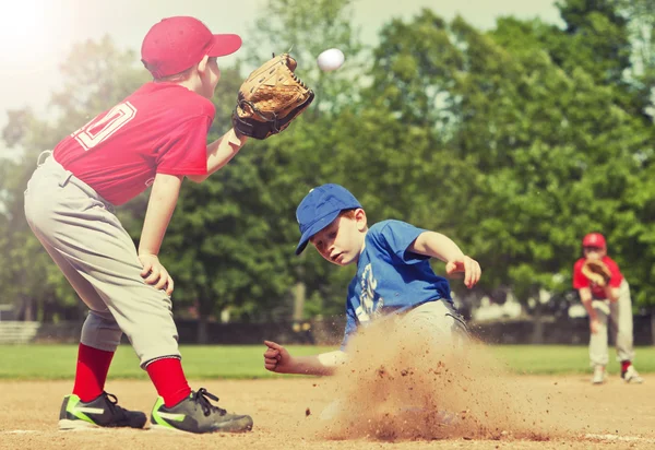 Jogador de beisebol deslizando para a base — Fotografia de Stock