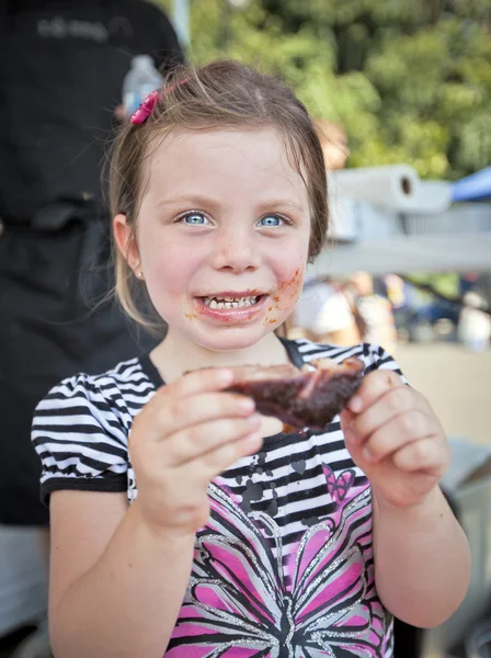 Young girl eating BBQ — 스톡 사진