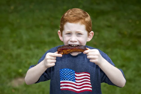 Niño comiendo costilla — Foto de Stock