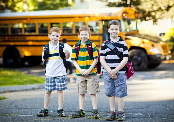 Três meninos e ônibus escolar — Fotografia de Stock