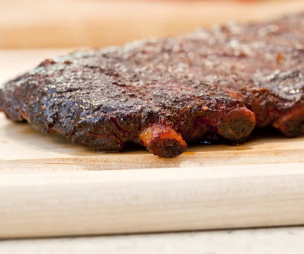 Costole da barbecue fresche su una tavola di legno — Foto Stock