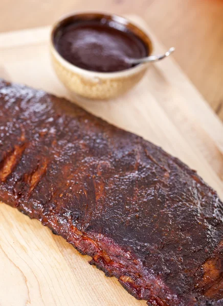 Côtes de barbecue fraîches sur une planche en bois — Photo