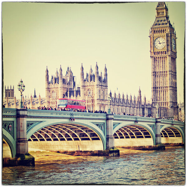 Red bus on Westminster Bridge by the Houses of Parliament with vintage filter effect