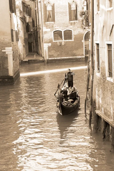 Gondolero llevando turistas en Venecia, tono sepia —  Fotos de Stock