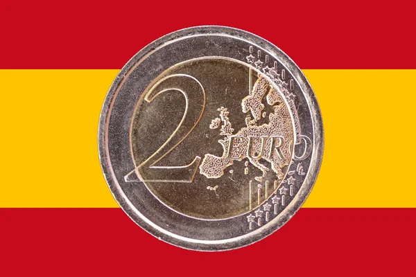 Common face of two euro coin on flag of Spain — Stock Photo, Image