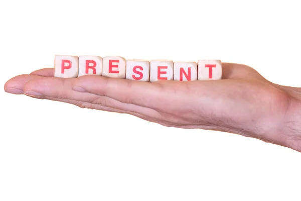 Presente scritto con dadi di legno su una mano, isolato su sfondo bianco — Foto Stock