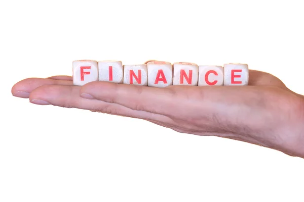 Finance skriven med trä dice på en hand, isolerad på vit bakgrund — Stockfoto