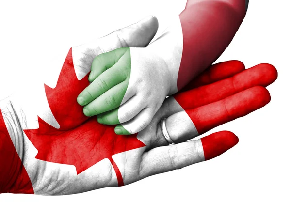 Hombre adulto sosteniendo una mano de bebé con banderas de Canadá e Italia superpuestas. Aislado sobre blanco — Foto de Stock