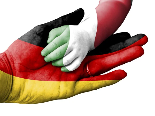 Dorosły człowiek trzyma rękę dziecka z Niemiec i Włoch flagi pokrył. Na białym tle — Zdjęcie stockowe