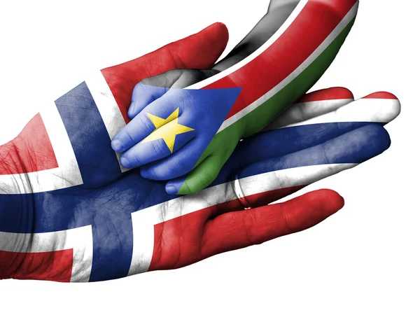 Felnőtt férfi egy baba kezemet, Norvégia és a Dél-Szudáni zászlók eltakarja. Elszigetelt fehér — Stock Fotó